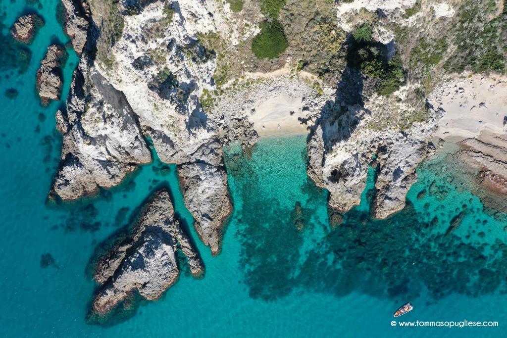 une vue aérienne sur l'océan entre deux îles rocheuses dans l'établissement Villa Kore, Capo Vaticano, à Capo Vaticano