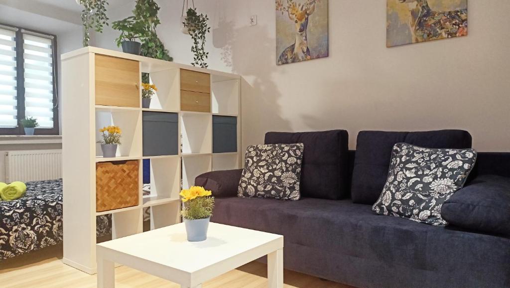 uma sala de estar com um sofá e uma mesa em Apartament Granatowy Świętoduska 12 em Lublin