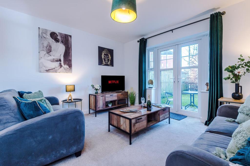 uma sala de estar com dois sofás azuis e uma televisão em Modern 4-Bed Townhouse in Crewe by 53 Degrees Property, Ideal for Contractors & Business, FREE Parking - Sleeps 8 em Crewe
