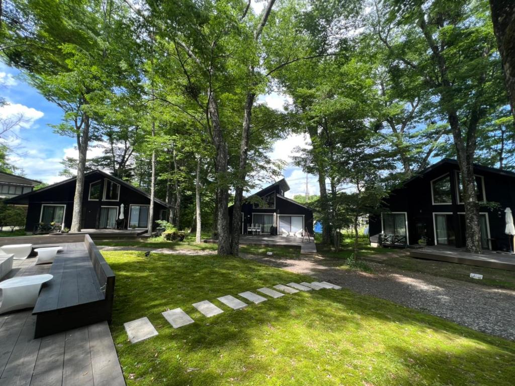 um quintal de uma casa com um banco na relva em Forest Villa Yamanakako em Yamanakako
