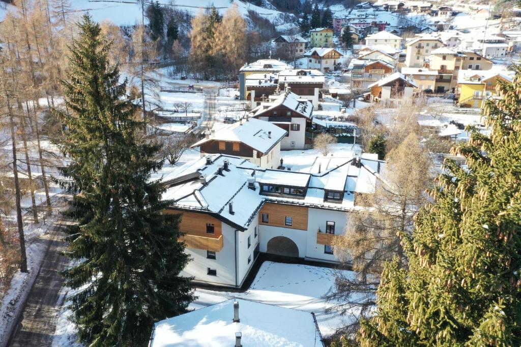 a small town covered in snow with houses at Appartamenti Residence Lares Ossana in Fucine