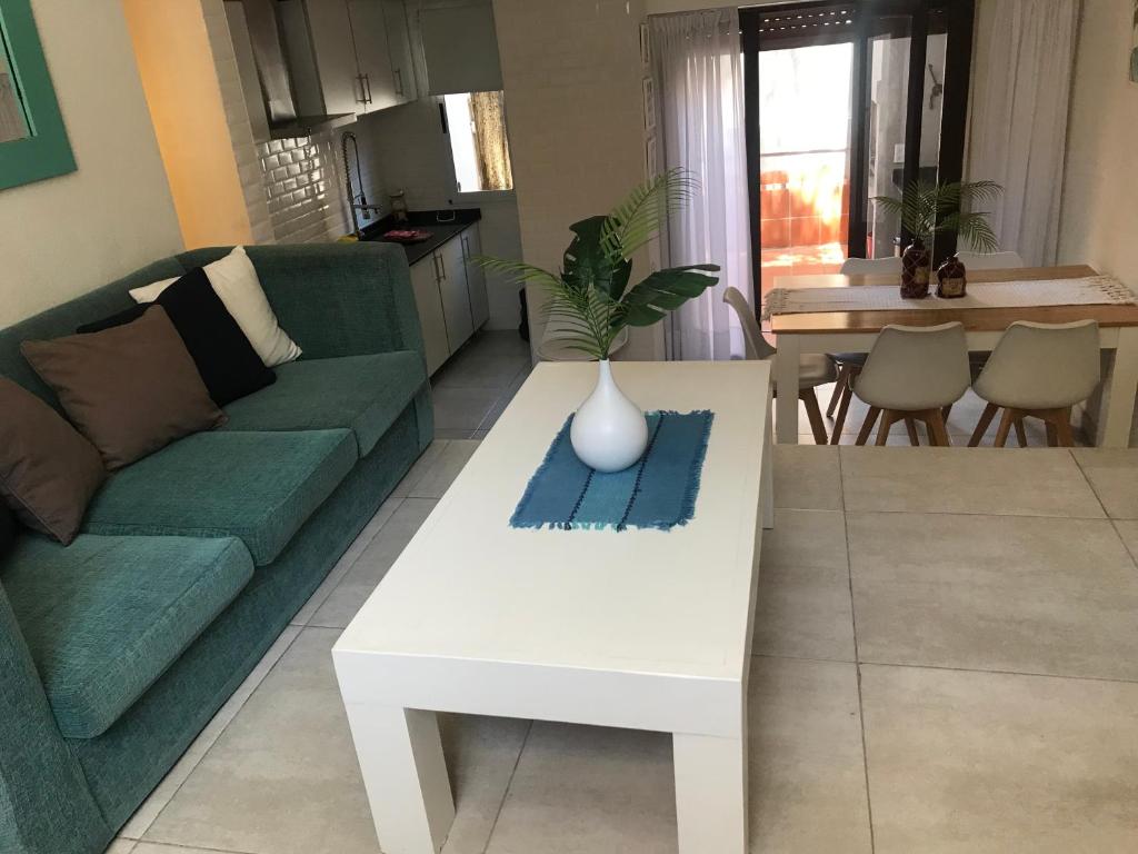 sala de estar con sofá verde y mesa de centro blanca en De La Lisa Triplex hasta 6 personas en Pinamar