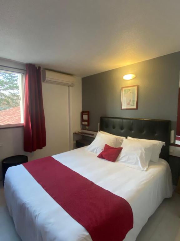 - une chambre avec un grand lit et une couverture rouge et blanche dans l'établissement Fasthotel Mont de Marsan, à Mont-de-Marsan