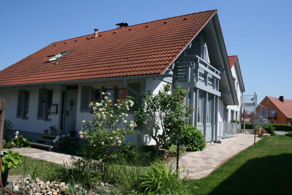 een wit huis met een rood dak bij Gästehaus Hauser in Rust