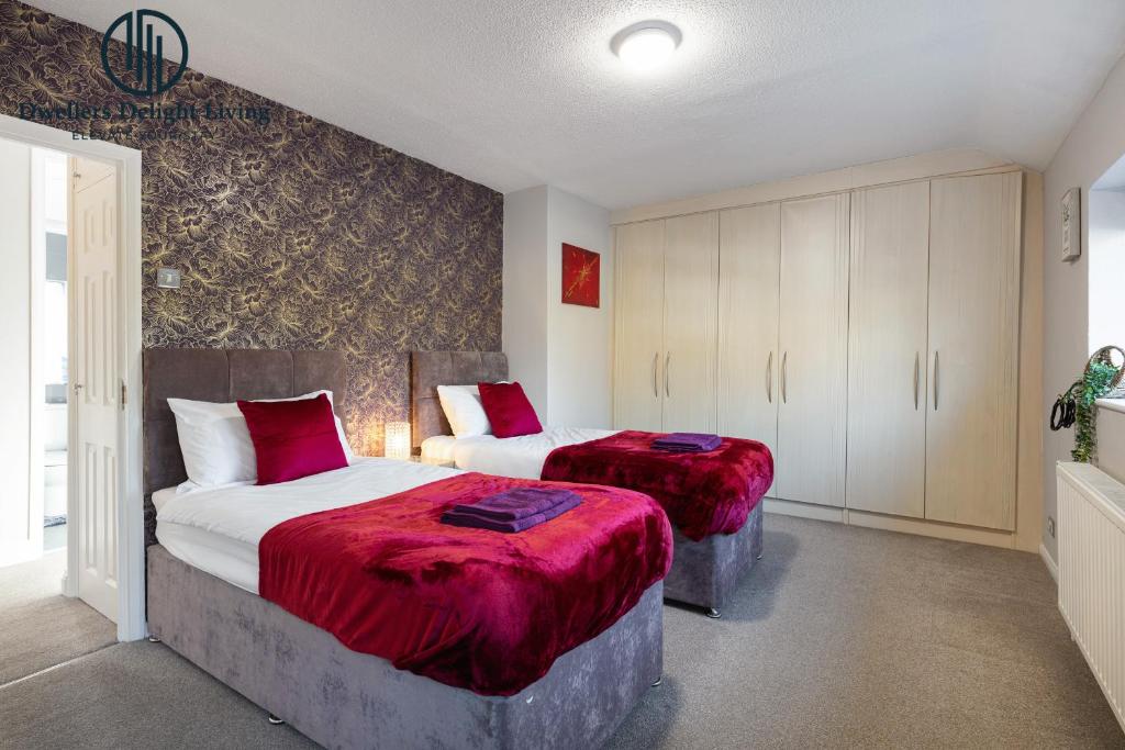 a bedroom with two beds with red blankets at Dwellers Delight Living Ltd 2 Bed House with Wi-Fi in Loughton, Essex in Loughton