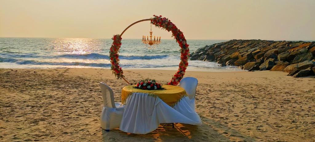 Una mesa en la playa con un pastel. en Marari Sailor Homes en Shertallai