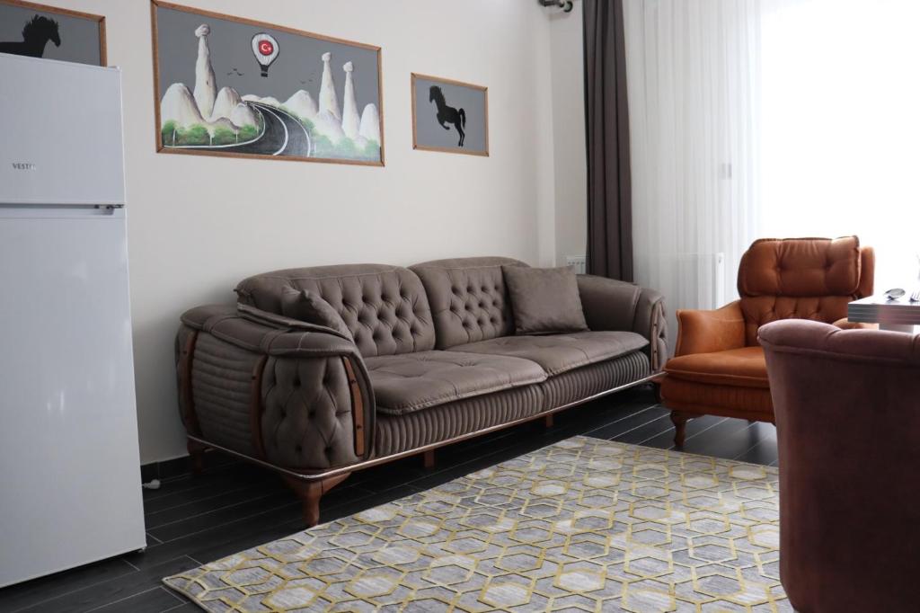 a living room with a brown couch and a chair at Loft Palace Suit in Nevsehir