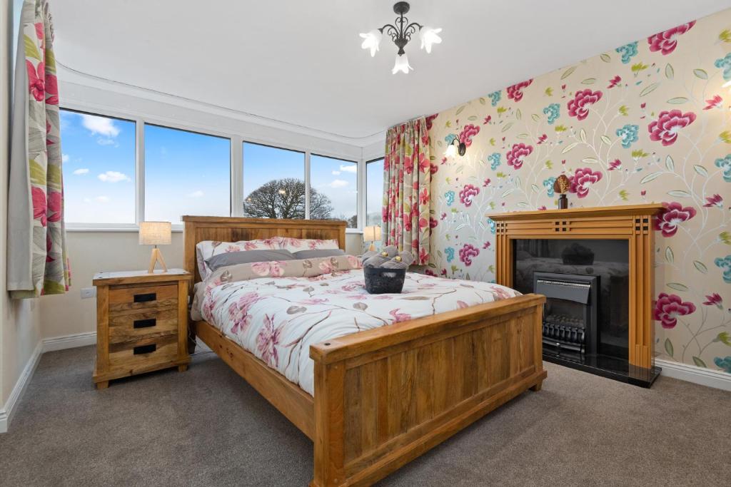 una camera con letto in legno e camino di Comfy Cumbrian Stay a Distington