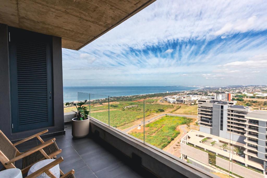 a balcony with chairs and a view of the ocean at Umhlanga Arch Luxury Holiday or Work with Sea View - Inverter Backup Power in Durban