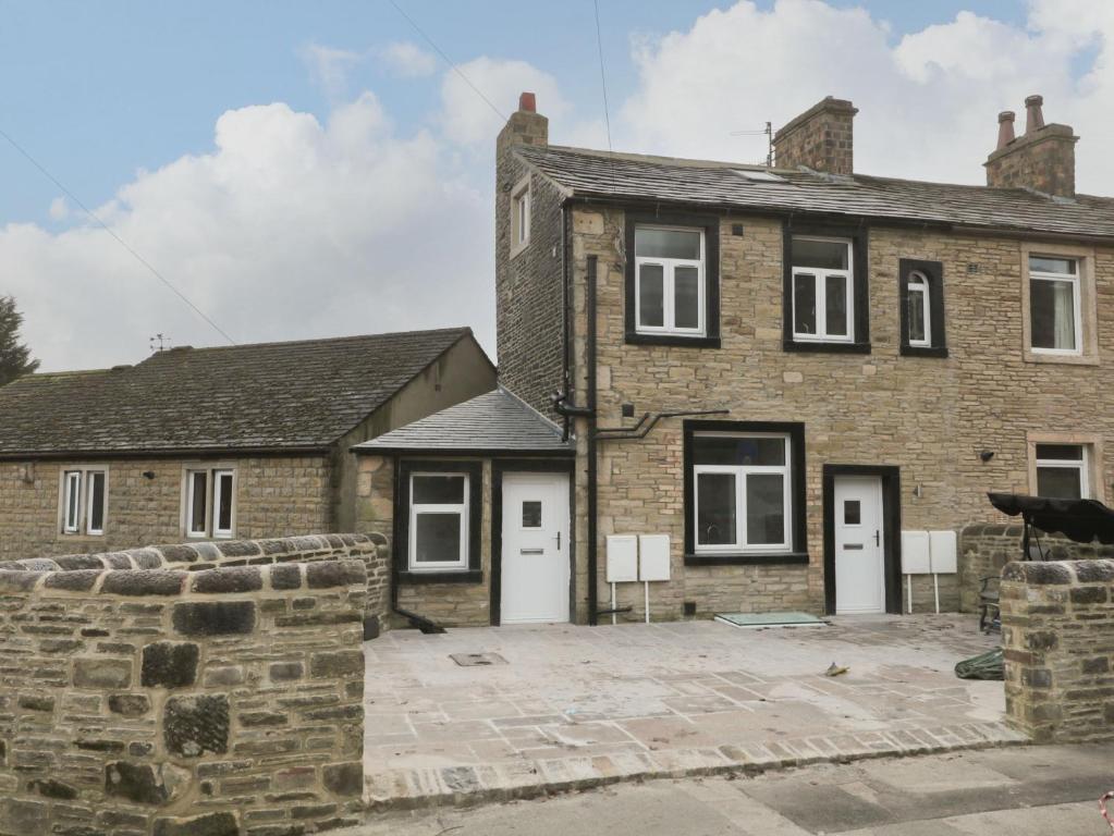 an old brick house with white doors and a courtyard at Moor View in Skipton