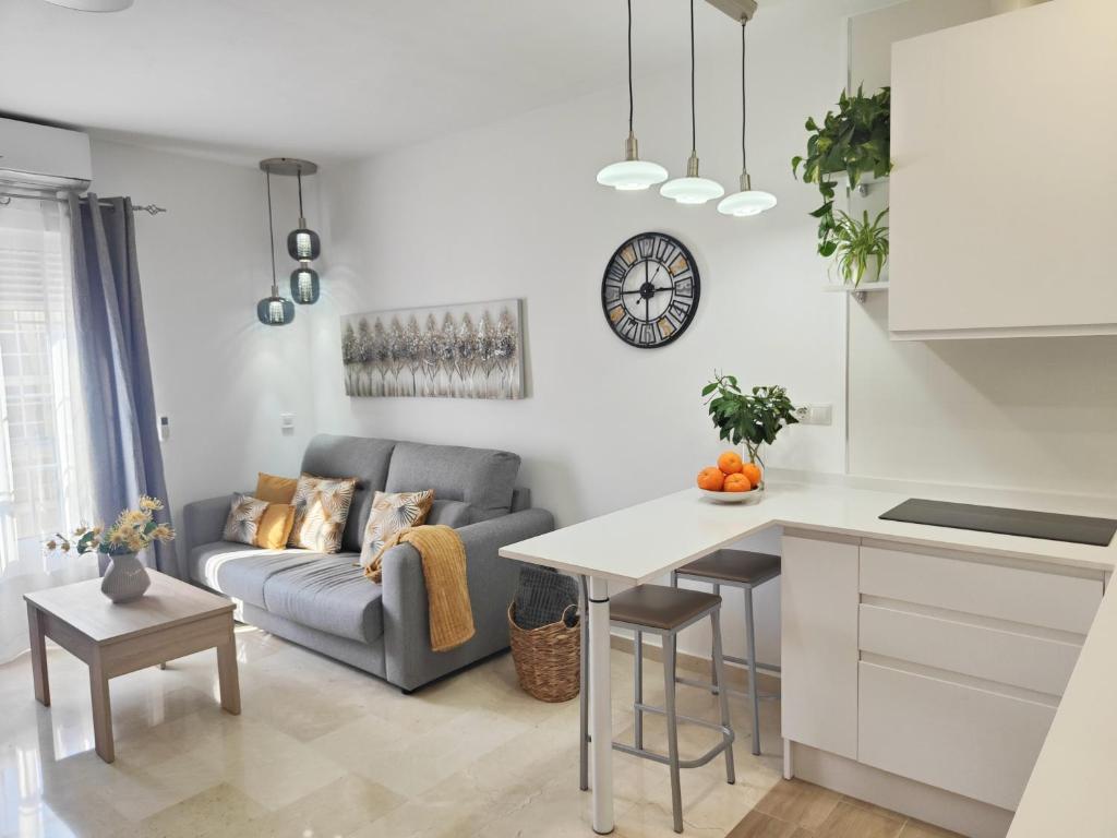 a kitchen and living room with a couch and a table at M&D Centro Málaga in Málaga