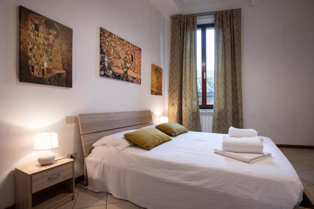 a bedroom with a large white bed and a window at Casato19 - Due passi da Piazza del Campo - NaonBnB in Siena