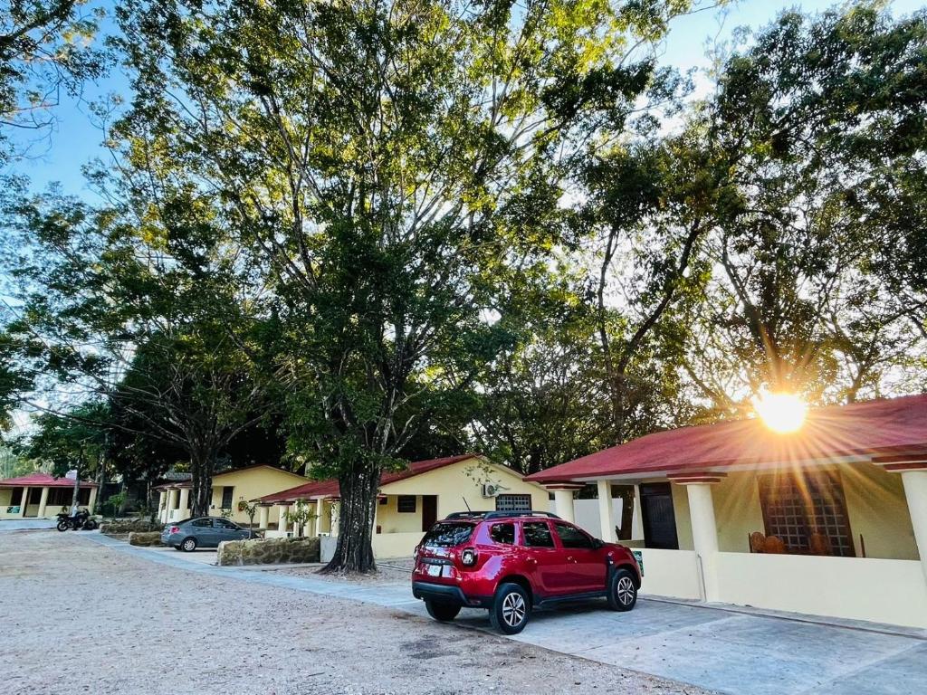 a red suv parked in front of a building at Cabañas Marisol in Palenque
