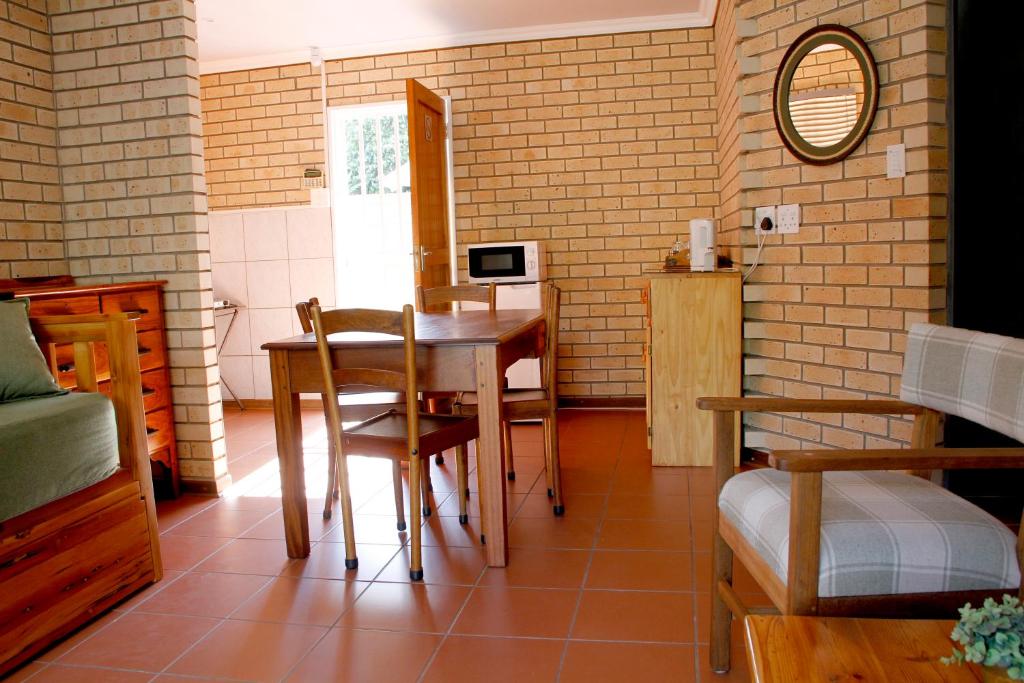 Habitación con mesa, sillas y espejo. en Vita Nova, en Bloemfontein