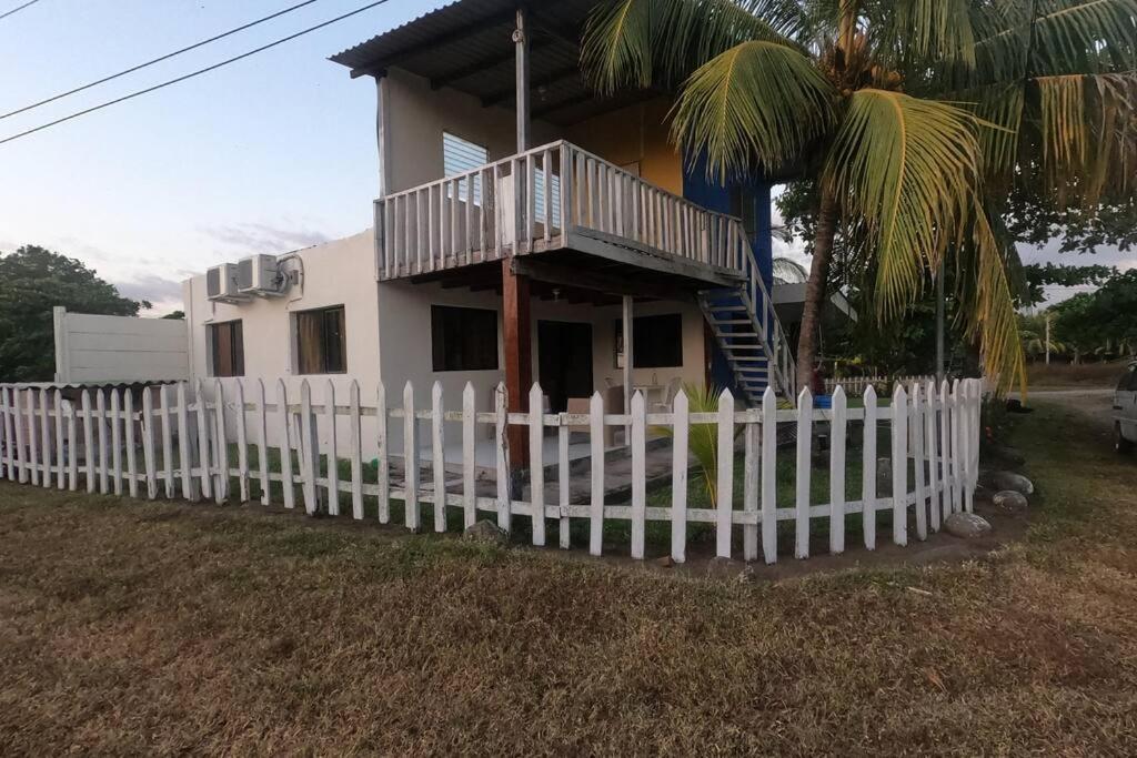 a white picket fence in front of a house at MALIBU HOUSE 