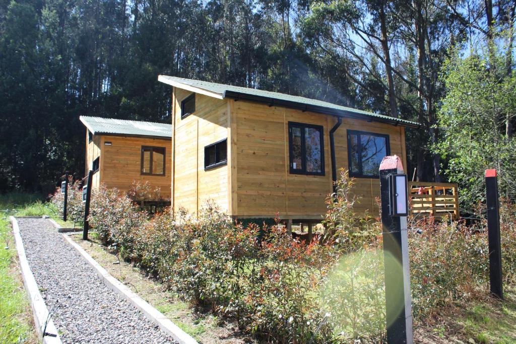 una pequeña casa de madera en medio de un campo en El Hostel Granjero, en Sesquilé