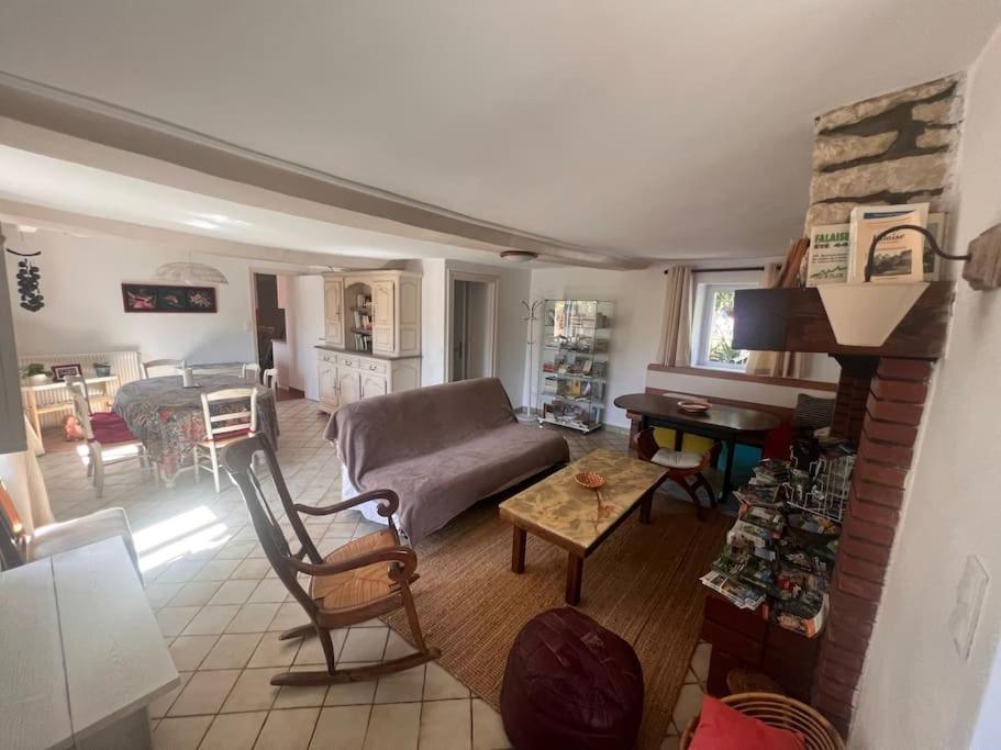 een woonkamer met een bank en een tafel bij Gîte Normand Le Merle blanc 2 à 6 personnes 