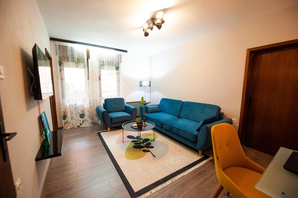 a living room with a blue couch and a table at Angelina Apartment in Bitola