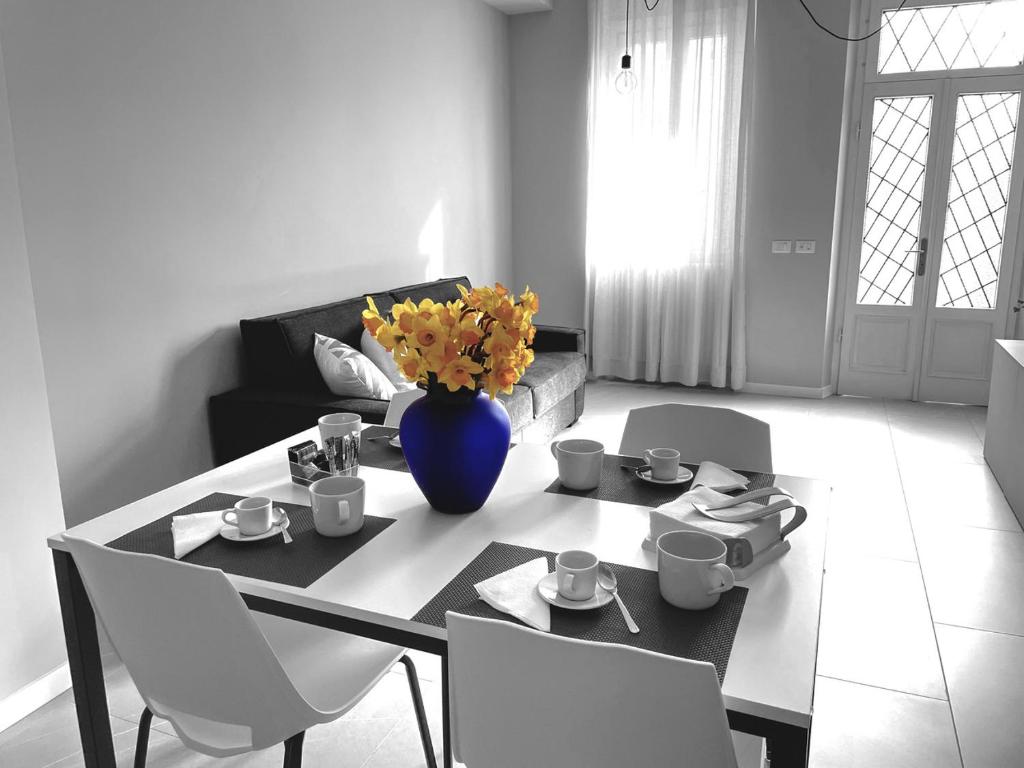 uma sala de estar com uma mesa com um vaso azul com flores em Ca'Sazen Bilo 18 em Brescia