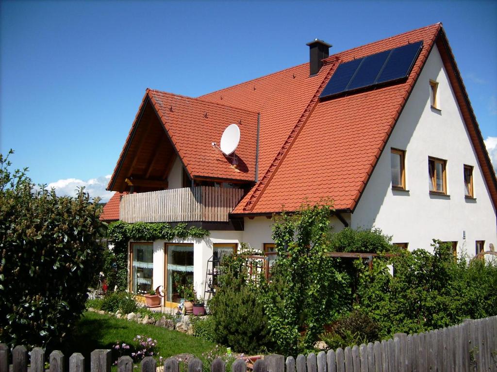a house with a red roof with a solar panel on it at Ferienwohnung Helga in Thalmässing