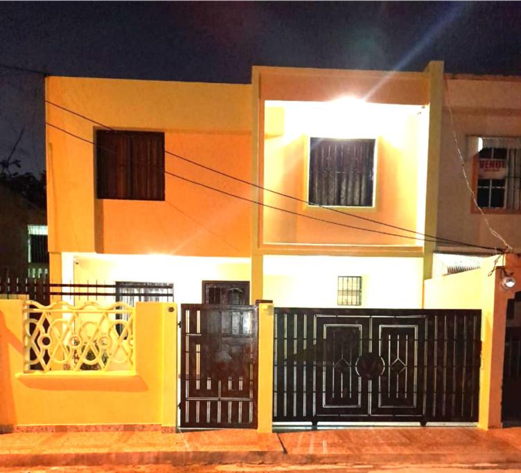 una casa amarilla y blanca con una puerta negra en casa equipada estadia placentera, en Hainamosa