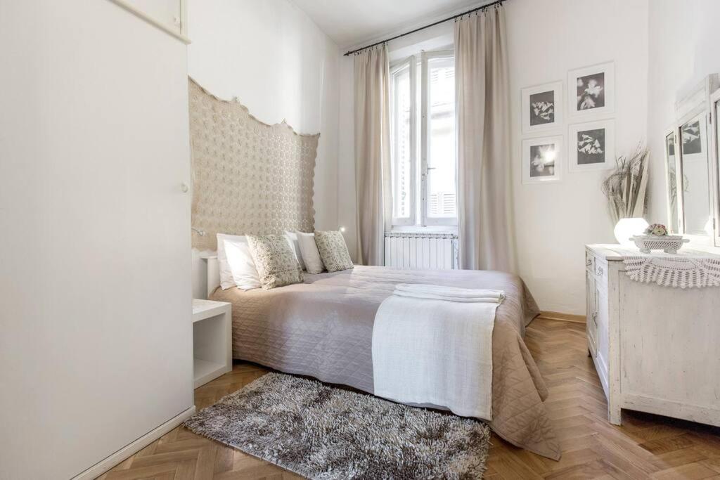 ein weißes Schlafzimmer mit einem Bett und einem Fenster in der Unterkunft Casa nei pressi del Duomo,Firenze centro storico in Florenz