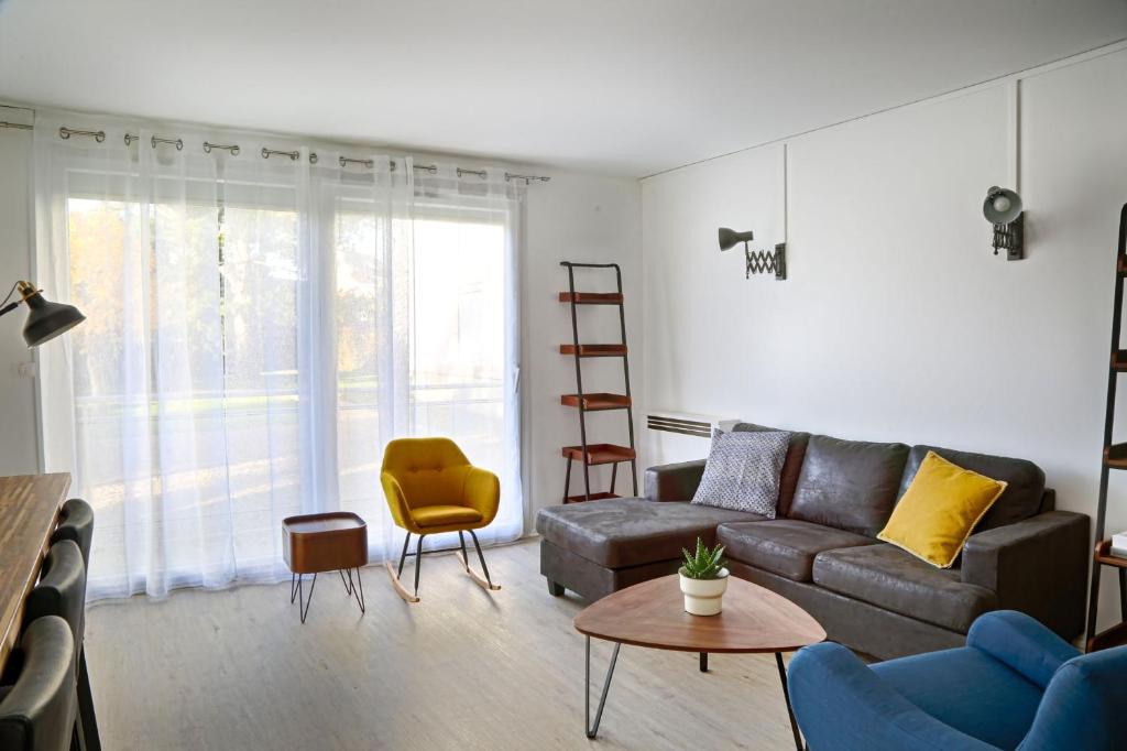 sala de estar con sofá y silla amarilla en Superbe appartement dans une résidence avec garage - 137, en Bihorel