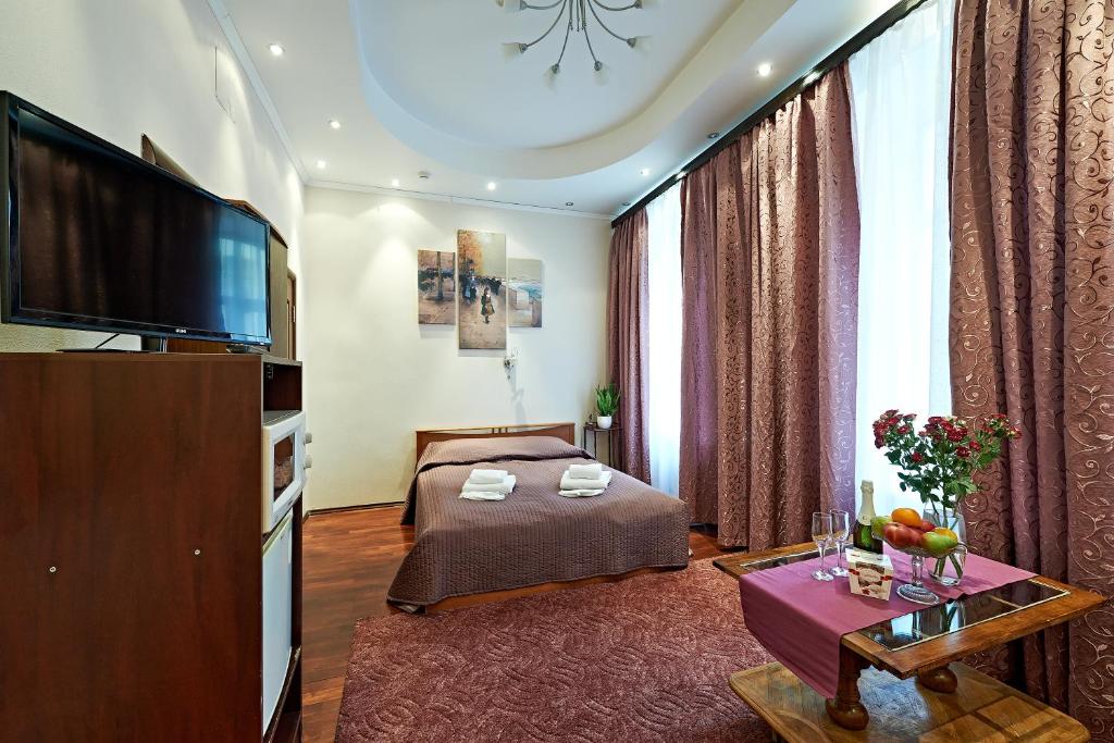 a hotel room with a bed and a flat screen tv at Pushkin Square in Saint Petersburg