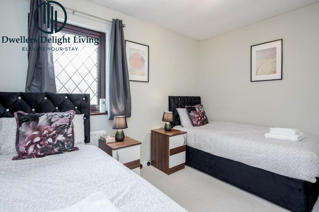 1 dormitorio con 2 camas y ventana en Dwellers Delight Living Ltd Serviced accommodation 2 Bed House, free Wifi & Parking, Prime Location London, Woodford, en Woodford Green