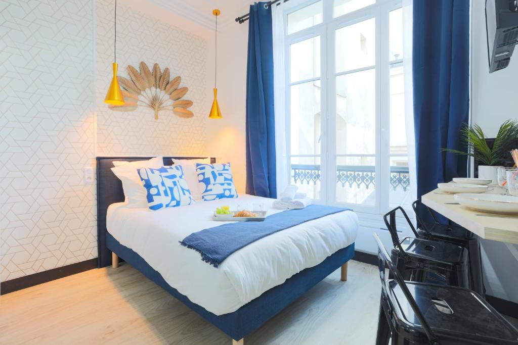 a bedroom with a bed with blue and white pillows at Apartments WS Hôtel de Ville - Beaubourg in Paris