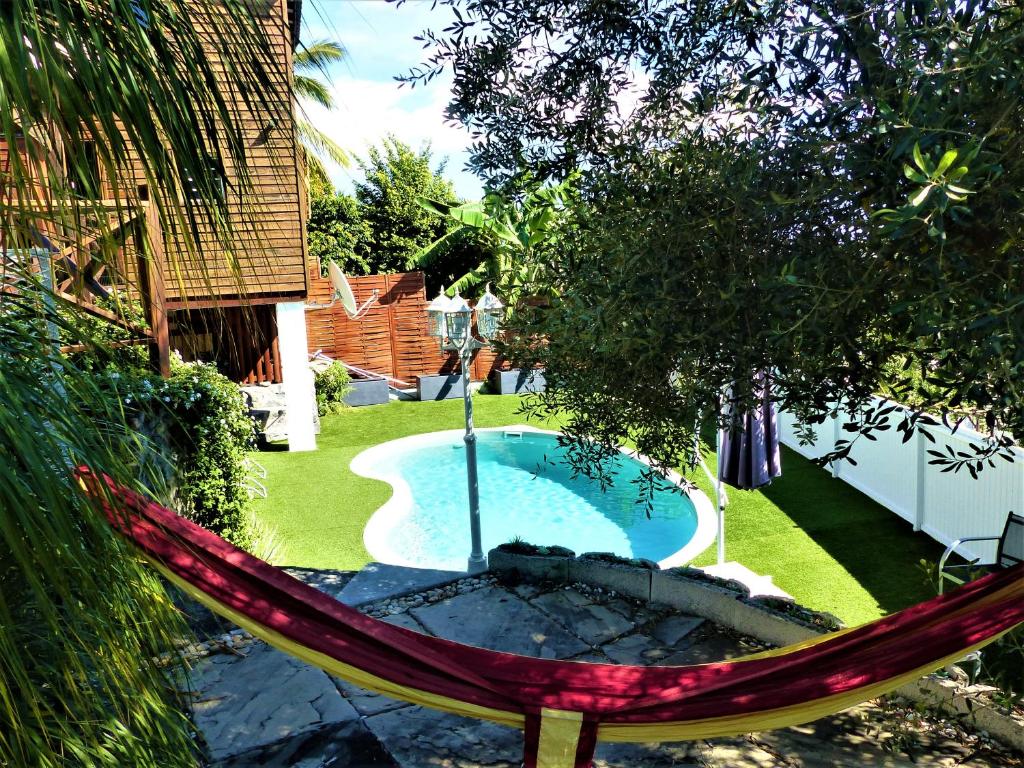 una hamaca en un patio con piscina en Le Clos de Val - Vue mer, en La Possession