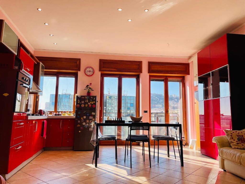 een keuken met rode kasten en een tafel met stoelen bij Napoli Centro in Napels