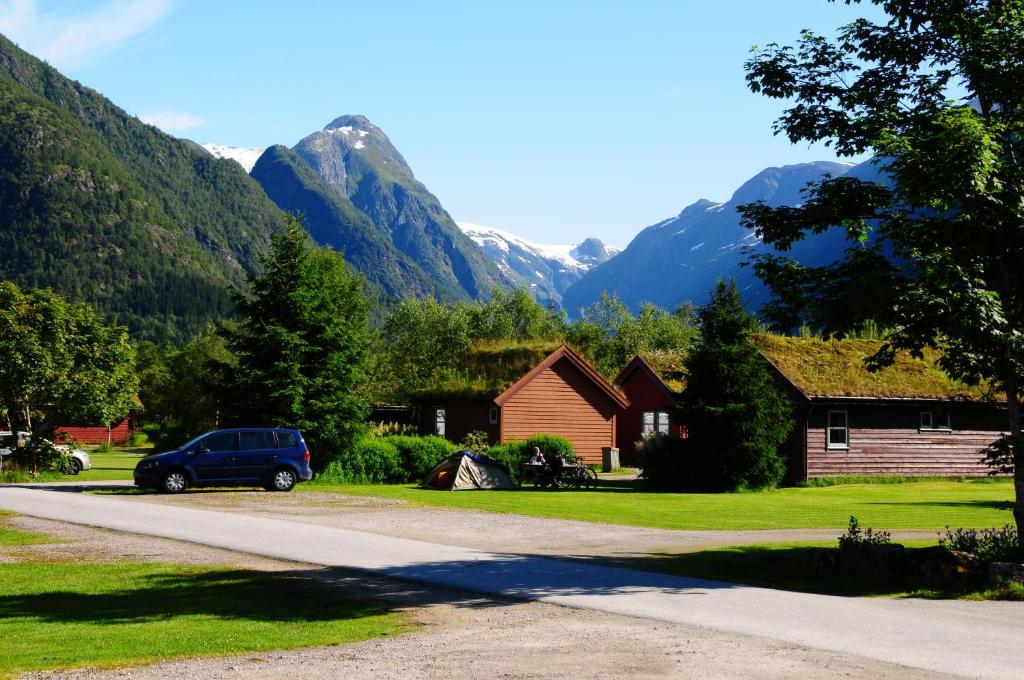 un'auto parcheggiata su una strada di fronte alle montagne di Bøyum Camping a Fjærland