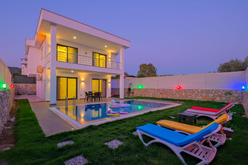a villa with a swimming pool in front of a house at Alternatif Villaları in Fethiye