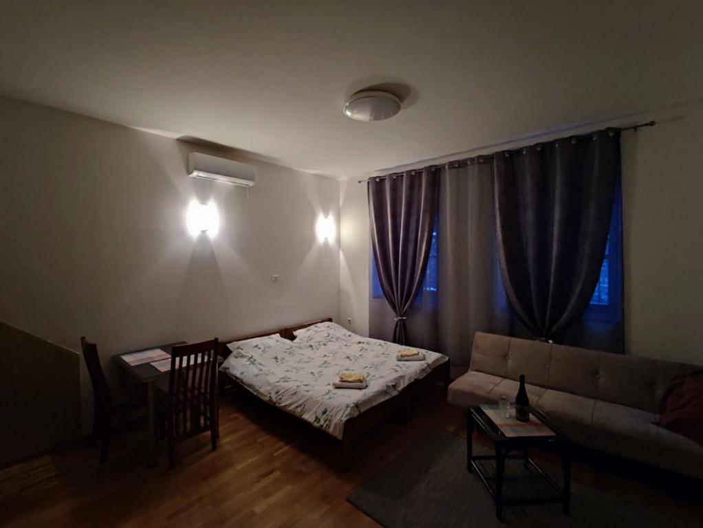 een woonkamer met een bank en een tafel en stoelen bij KONAK MALI in Sarajevo