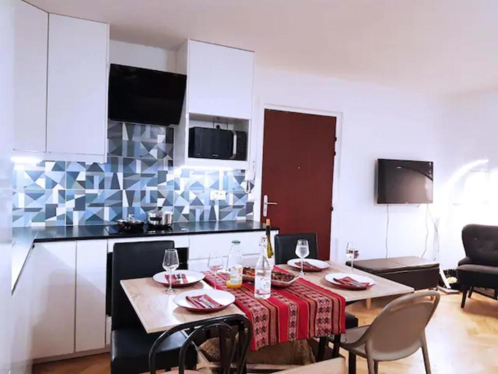 een woonkamer met een tafel en een keuken bij Pretty and neat bedroom in my cosy appartment. in Puteaux