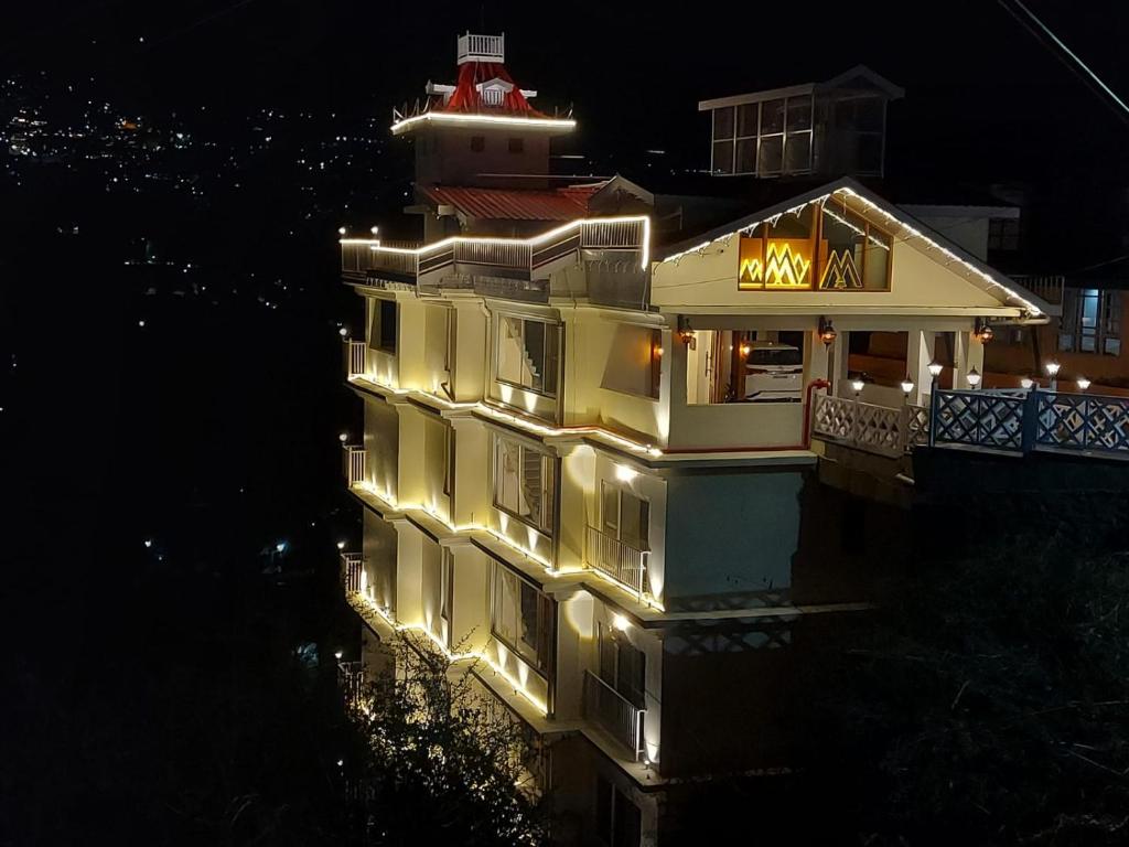 um edifício iluminado com uma casa de luz com um farol em Meraki shimla em Shimla