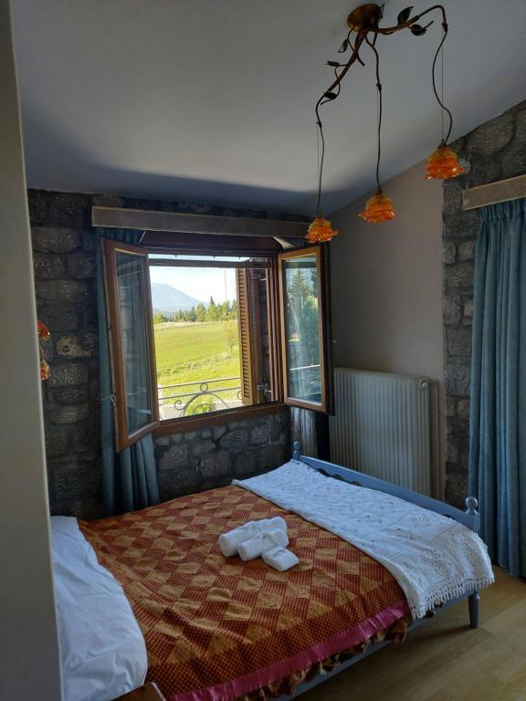 ein Schlafzimmer mit einem Bett und einem großen Fenster in der Unterkunft Xenios Petritis in Livadia