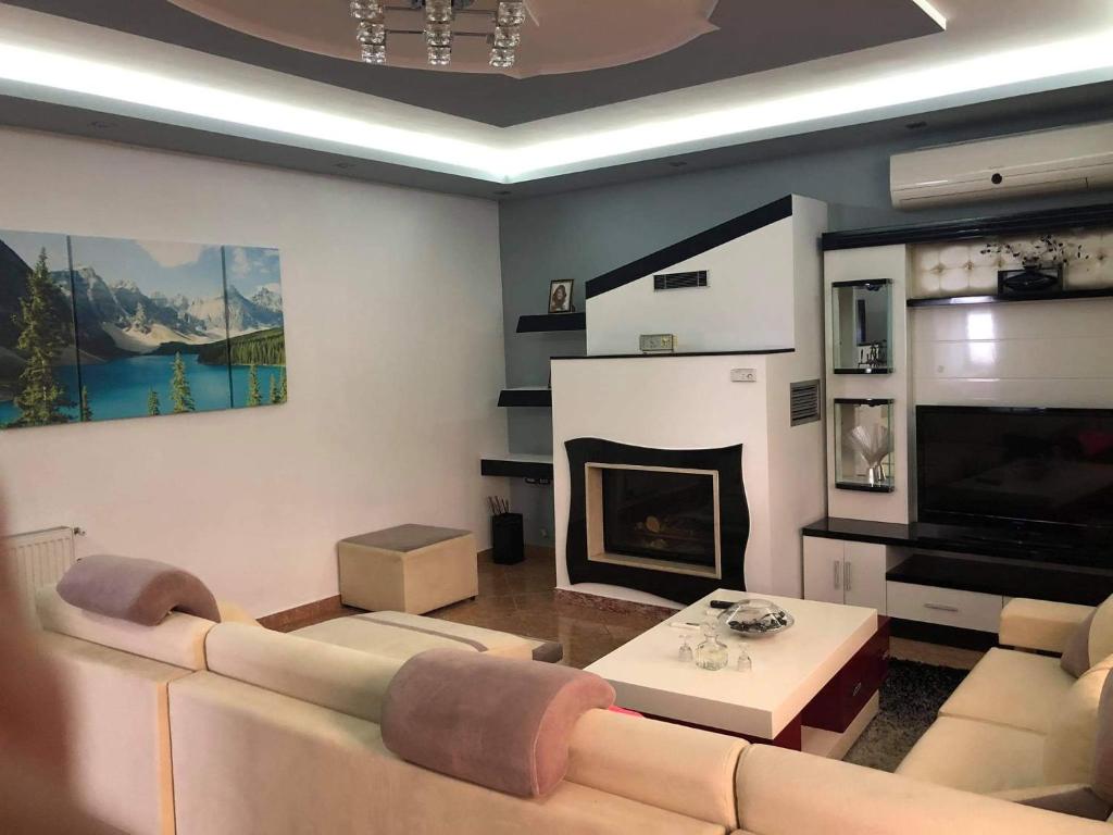 a living room with a couch and a fireplace at Villa Ceni 2 in Elbasan