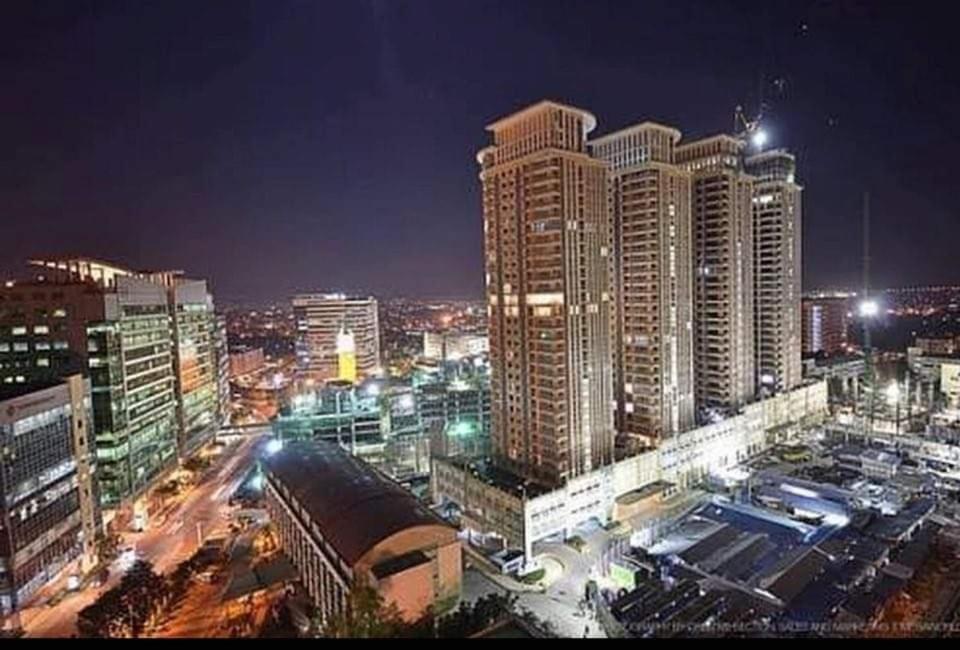 a city skyline with tall buildings at night at Morgan Suite BGC Shortwalk2 Venice Mall free pool gym in Manila