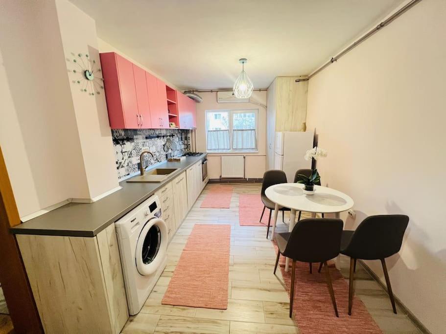 cocina con lavadora y mesa con sillas en 2 Bedroom Apartment and Separate Kitchen 52mp, en Timisoara