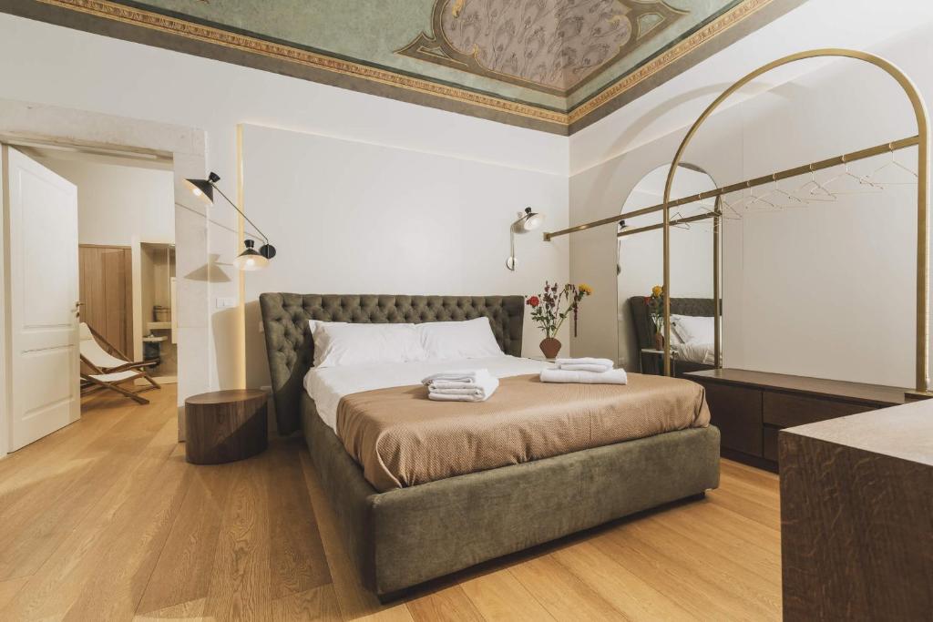 ラクイラにあるCasa Horti Suitesのベッドルーム1室(ベッド1台、壁掛け鏡付)