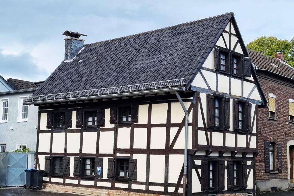 een oud zwart-wit gebouw met een zwart dak bij altes romantisches Fachwerkhaus in Rheinnähe auch für Workation geeignet in Keulen