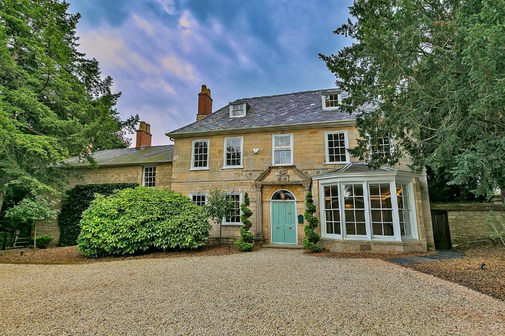 una gran casa de ladrillo con puerta azul en Finest Retreats - Ttich Manor en Milton Keynes