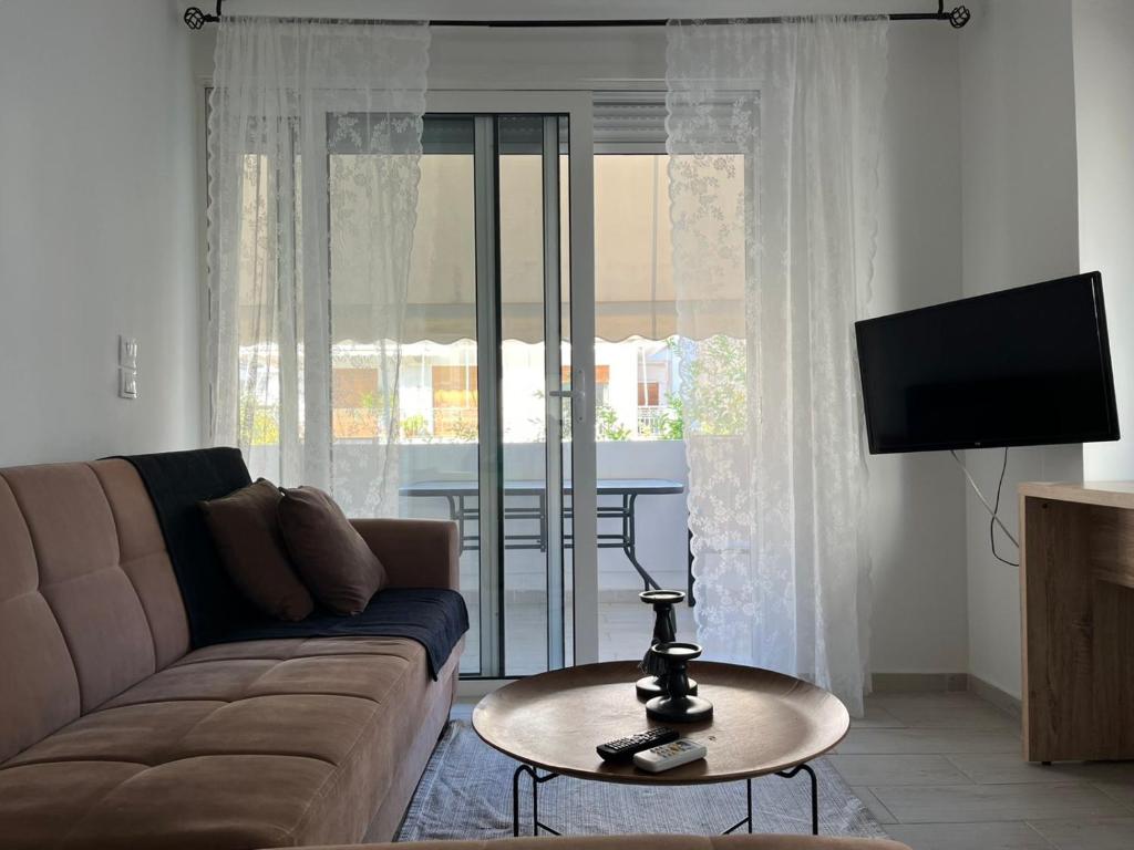 a living room with a couch and a table at Holiday Apartment Glyfada in Athens