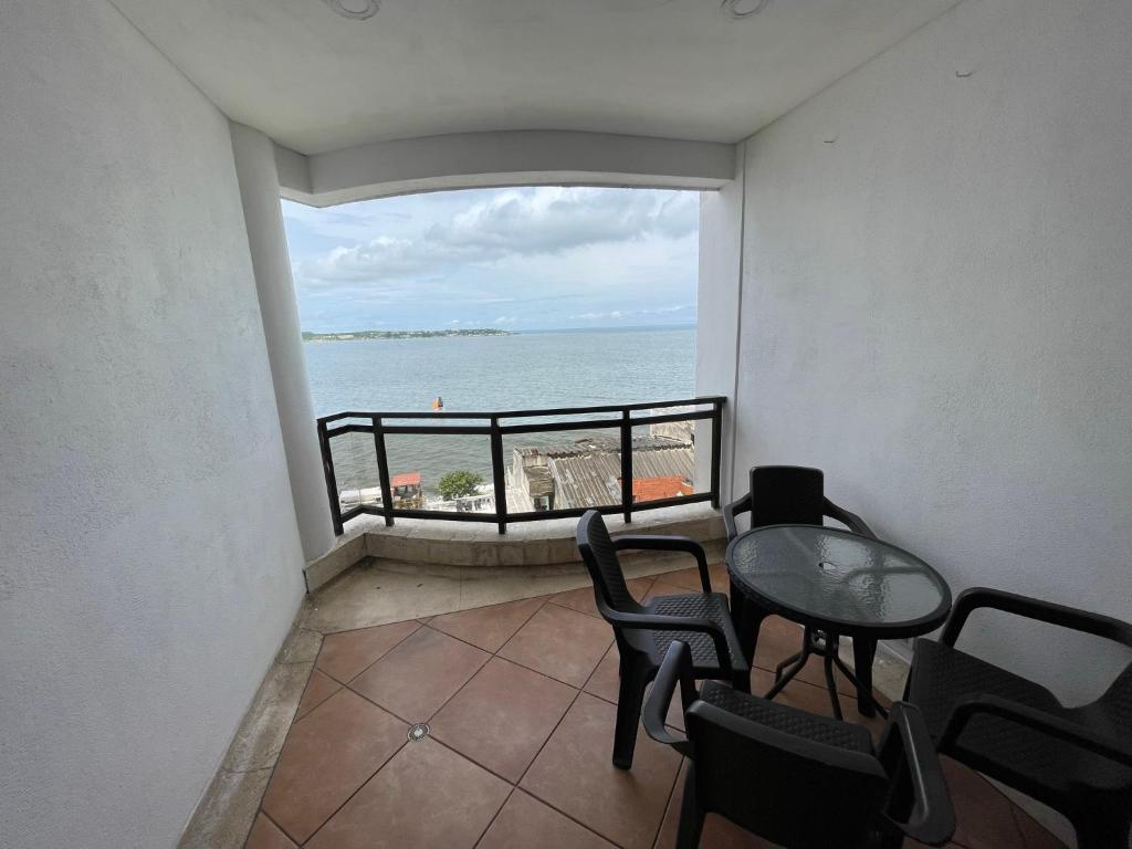 einen Balkon mit einem Tisch und Stühlen sowie Meerblick in der Unterkunft Apartamento familiar. in Cartagena de Indias