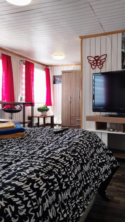 Una televisión o centro de entretenimiento en Hostal Host Patagonia