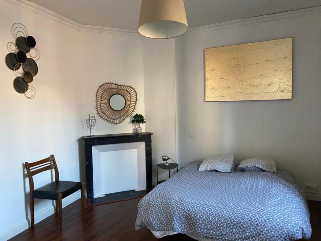 a bedroom with a bed and a mirror and a fireplace at CosyRouen Gare in Rouen