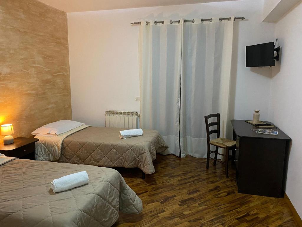 ein Hotelzimmer mit 2 Betten und einem Schreibtisch mit einem Computer in der Unterkunft B&B Spanò in Polistena