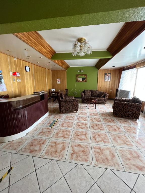 um átrio com um bar e cadeiras e paredes verdes em HOSPEDAJE DA VINCI PARA TURISTAS y PERSONAL LABORAL em Calama